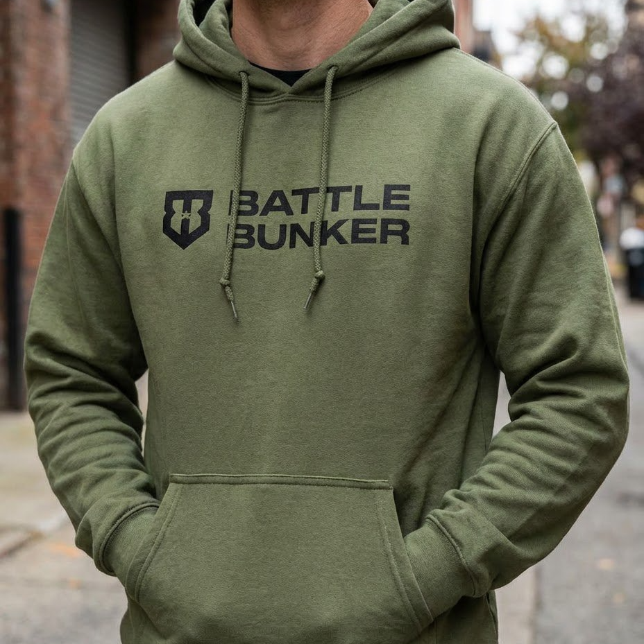 Person wearing a green hoodie with 'Battle Bunker' logo on a street.