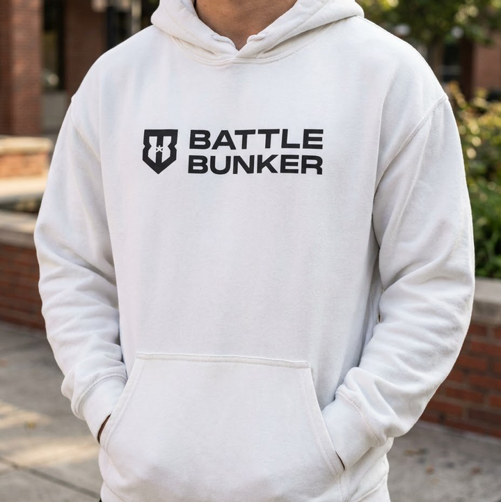 Person wearing a white hoodie with 'Battle Bunker' logo outdoors.