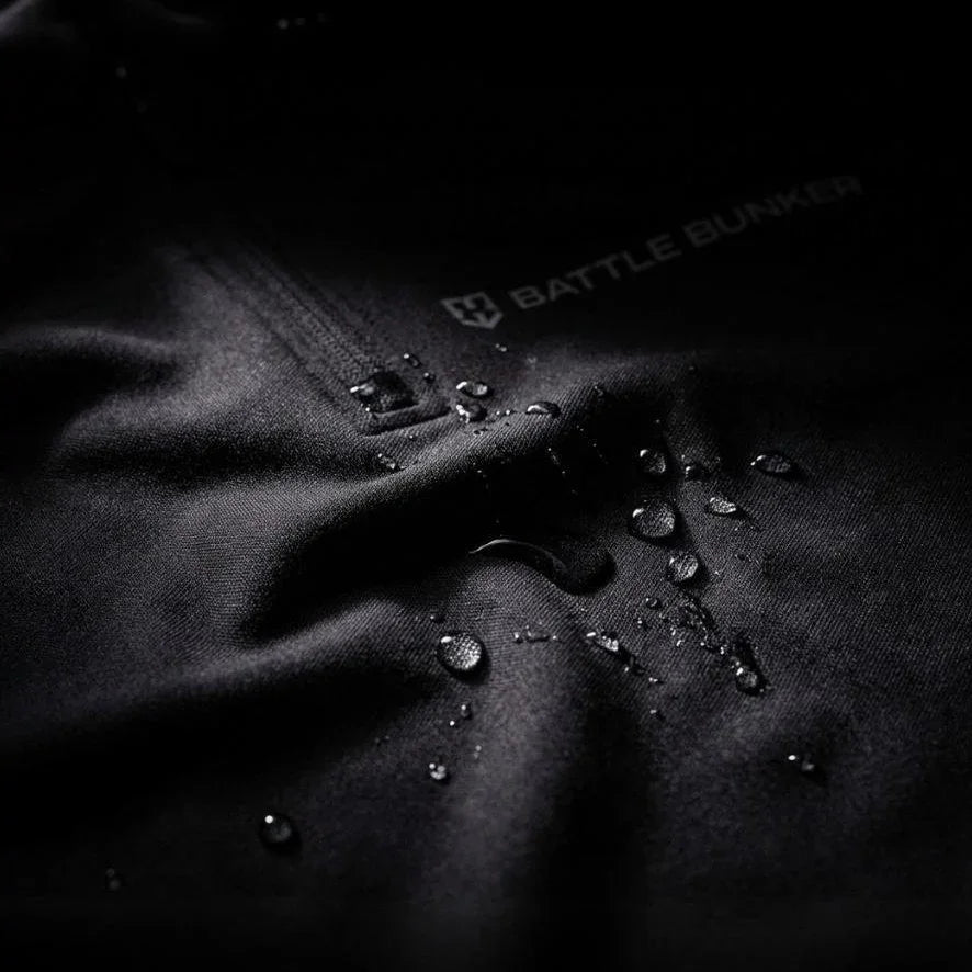 Close-up of black Battle Bunker fabric with water droplets showcasing waterproof textile and branding