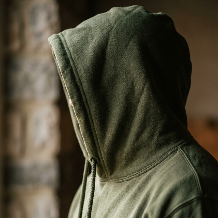 Person wearing a green hoodie with a blurred background