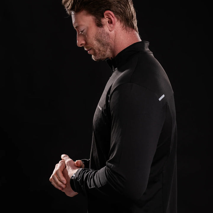 Man wearing black Battle Bunker quarter-zip athletic top against black background